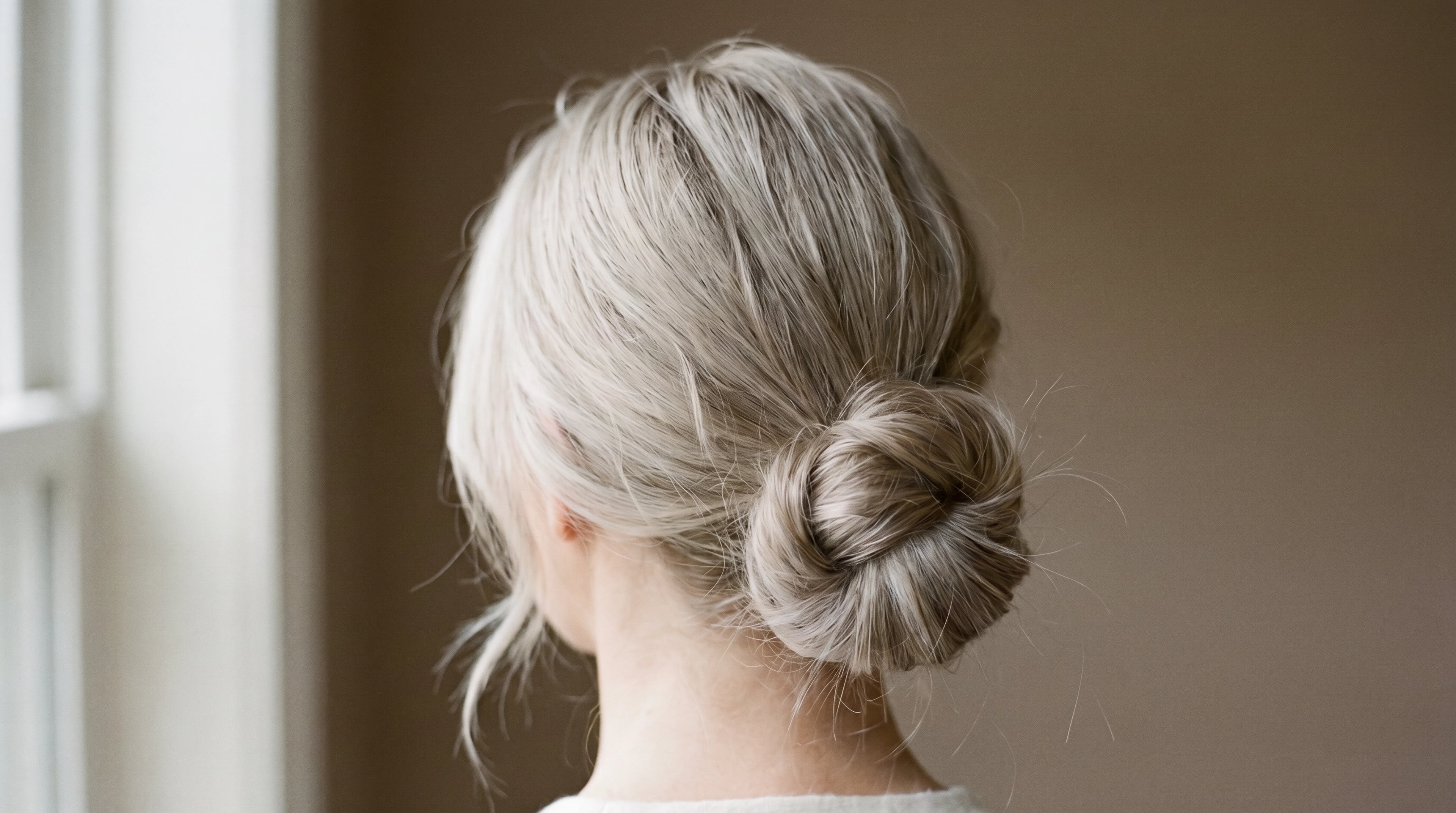 Black and white editorial portrait of woman with raw virgin tape-in hair extensions photographed from behind